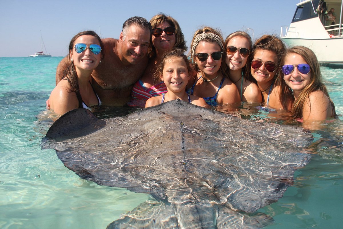 Family with stingrays on sandbar